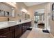Bathroom featuring dual sinks, dark wood cabinets, and large vanity mirrors at 15665 W Coronado Rd, Goodyear, AZ 85395