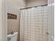 Neutral bathroom featuring shower with patterned curtain and 'be sweet' wall decor at 15665 W Coronado Rd, Goodyear, AZ 85395