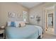 Neutral toned bedroom with large windows, wall decor, side table, and carpet at 15665 W Coronado Rd, Goodyear, AZ 85395