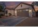 Front elevation of single Gathering home and long driveway at dusk at 15665 W Coronado Rd, Goodyear, AZ 85395