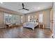 Bright main bedroom with a fan, wood floors, ample windows, and comfortable seating area at 15665 W Coronado Rd, Goodyear, AZ 85395