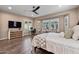 Comfortable main bedroom with a ceiling fan, wood floors, ample windows, and a built-in desk at 15665 W Coronado Rd, Goodyear, AZ 85395