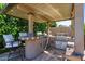 Outdoor kitchen is equipped with a grill, sink, beverage fridge, bar seating and pendant lights at 15665 W Coronado Rd, Goodyear, AZ 85395