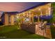 Inviting outdoor kitchen with bar seating, lush landscaping and putting green at 15665 W Coronado Rd, Goodyear, AZ 85395