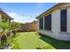 Well-manicured putting green with flags, string lights, and mature landscaping offers a fun outdoor experience at 15665 W Coronado Rd, Goodyear, AZ 85395