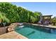 Beautiful pool with a waterfall feature and lush landscaping, perfect for relaxation at 15665 W Coronado Rd, Goodyear, AZ 85395