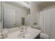 Bathroom featuring a sink, mirror, toilet and shower with white tile and a decorative plant at 15962 W Gibson Ln, Goodyear, AZ 85338