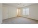 A bright bedroom with carpet flooring, a ceiling fan, window, and closet with doors at 15962 W Gibson Ln, Goodyear, AZ 85338