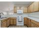 Well-lit kitchen featuring wood cabinets, white appliances and an open layout to the living space at 15962 W Gibson Ln, Goodyear, AZ 85338