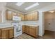 Bright kitchen featuring wood cabinetry, white appliances, and skylights for a naturally lit space at 15962 W Gibson Ln, Goodyear, AZ 85338