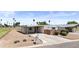 Well-maintained home with a long driveway, small garden and rock detail with a golf course visible in the distance at 1641 S Sossaman Rd, Mesa, AZ 85209