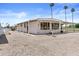 Bright white home featuring an enclosed porch, surrounded by gravel landscaping and tall palm trees at 1641 S Sossaman Rd, Mesa, AZ 85209