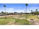 Scenic view of the home's location on a vibrant golf course with mature palm trees and manicured greens at 1641 S Sossaman Rd, Mesa, AZ 85209