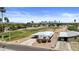 Well-kept single-story home with a carport, lush green lawn and palm trees with mountain views in the distance at 1641 S Sossaman Rd, Mesa, AZ 85209
