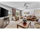 Spacious living room with large windows, ceiling fan, TV, and plush seating at 1641 S Sossaman Rd, Mesa, AZ 85209