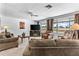 Spacious living room with large windows, ceiling fan, TV, and plush seating at 1641 S Sossaman Rd, Mesa, AZ 85209