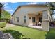 Beautiful backyard with a covered patio, manicured lawn, and colorful landscaping at 16466 W Lariat Ln, Surprise, AZ 85387