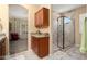 Bathroom with tiled shower, granite countertop, and backyard view at 16466 W Lariat Ln, Surprise, AZ 85387