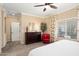 Bright bedroom features large window, ceiling fan, and a red accent chair at 16466 W Lariat Ln, Surprise, AZ 85387