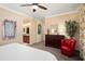 Comfortable bedroom features a dresser, red chair, and connecting access to the bathroom at 16466 W Lariat Ln, Surprise, AZ 85387