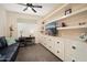 Cozy den features built-in cabinets, a sofa, a desk, and ample lighting at 16466 W Lariat Ln, Surprise, AZ 85387