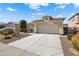 Well-maintained home with a spacious driveway, desert landscaping, and a two-car garage at 16466 W Lariat Ln, Surprise, AZ 85387