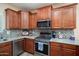 Updated kitchen with stainless steel appliances, granite countertops and tiled backsplash at 16466 W Lariat Ln, Surprise, AZ 85387