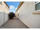Narrow side yard of a home with gravel and a row of small trees at 16466 W Lariat Ln, Surprise, AZ 85387