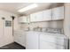 Clean laundry room with washer, dryer, cabinets and sink at 17200 W Bell Rd # 1202, Surprise, AZ 85374