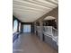 A covered patio with decorative columns, double door, and stairway to an elevated seating area at 17200 W Bell Rd # 1202, Surprise, AZ 85374