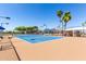 Well-maintained tennis court with blue and tan surface and palm trees at 17200 W Bell Rd # 1202, Surprise, AZ 85374