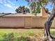 Backyard view of block wall with a mature tree and some desert landscaping at 17838 N 45Th Ave, Glendale, AZ 85308