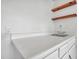 Wet bar features white countertop, white cabinets, stainless steel sink and wood shelves at 17838 N 45Th Ave, Glendale, AZ 85308