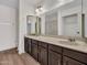 En suite bathroom features dual sinks with dark cabinets and a shower behind a glass door at 17838 N 45Th Ave, Glendale, AZ 85308