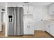 Stainless steel refrigerator next to white cabinets in kitchen on wood floor at 17838 N 45Th Ave, Glendale, AZ 85308