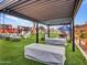 Stylish outdoor seating with comfortable white chairs and lounge benches under string lights and pergola at 17838 N 45Th Ave, Glendale, AZ 85308