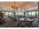 Elegant dining room with stylish seating arrangements, chandeliers, and views of the desert landscape at 19115 E Buckskin Ct, Rio Verde, AZ 85263