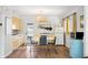Bright kitchen with white brick walls, yellow cabinets, stainless steel appliances, and a dining table at 2039 N 12Th St, Phoenix, AZ 85006