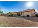 The backyard has desert landscaping, covered patio, tan exterior, and tile roof at 20717 N 104Th Ln, Peoria, AZ 85382