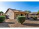 The backyard features desert landscaping, covered patio, tan exterior, and tile roof at 20717 N 104Th Ln, Peoria, AZ 85382
