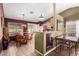 Open-concept dining area with a glass table and chairs with outdoor views and access to kitchen at 20717 N 104Th Ln, Peoria, AZ 85382