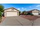 A well maintained single-story home featuring a neutral-toned exterior, desert landscaping, and a two-car garage at 20717 N 104Th Ln, Peoria, AZ 85382