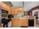 Bright kitchen featuring light wood cabinets, essential appliances, and a convenient breakfast bar at 20717 N 104Th Ln, Peoria, AZ 85382