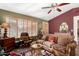 Comfortable living room with ceiling fan, rustic wood floors, comfortable seating, and natural light streaming through windows at 20717 N 104Th Ln, Peoria, AZ 85382