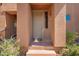 Inviting front door of a charming home, surrounded by lush greenery and a warm, welcoming facade at 20801 N 90Th Pl # 210, Scottsdale, AZ 85255