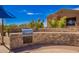 Outdoor grill area with stone countertop, stainless grill and partial building view at 20801 N 90Th Pl # 210, Scottsdale, AZ 85255