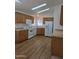 Bright kitchen features wood cabinets, white appliances, and laminate flooring at 2233 E Behrend Dr # 211, Phoenix, AZ 85024