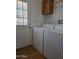 Laundry room featuring appliances, storage cabinet, and utility door at 2233 E Behrend Dr # 211, Phoenix, AZ 85024