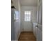 Functional laundry area including a utility door, appliances, and wood-look flooring at 2233 E Behrend Dr # 211, Phoenix, AZ 85024