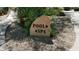 Stone sign directing to the pool and spa amidst desert landscaping and walking paths at 2233 E Behrend Dr # 211, Phoenix, AZ 85024